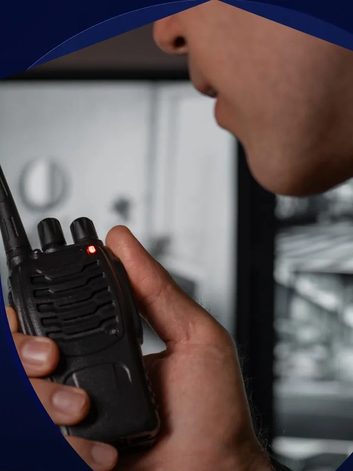 Mão segurando um rádio comunicador na portaria